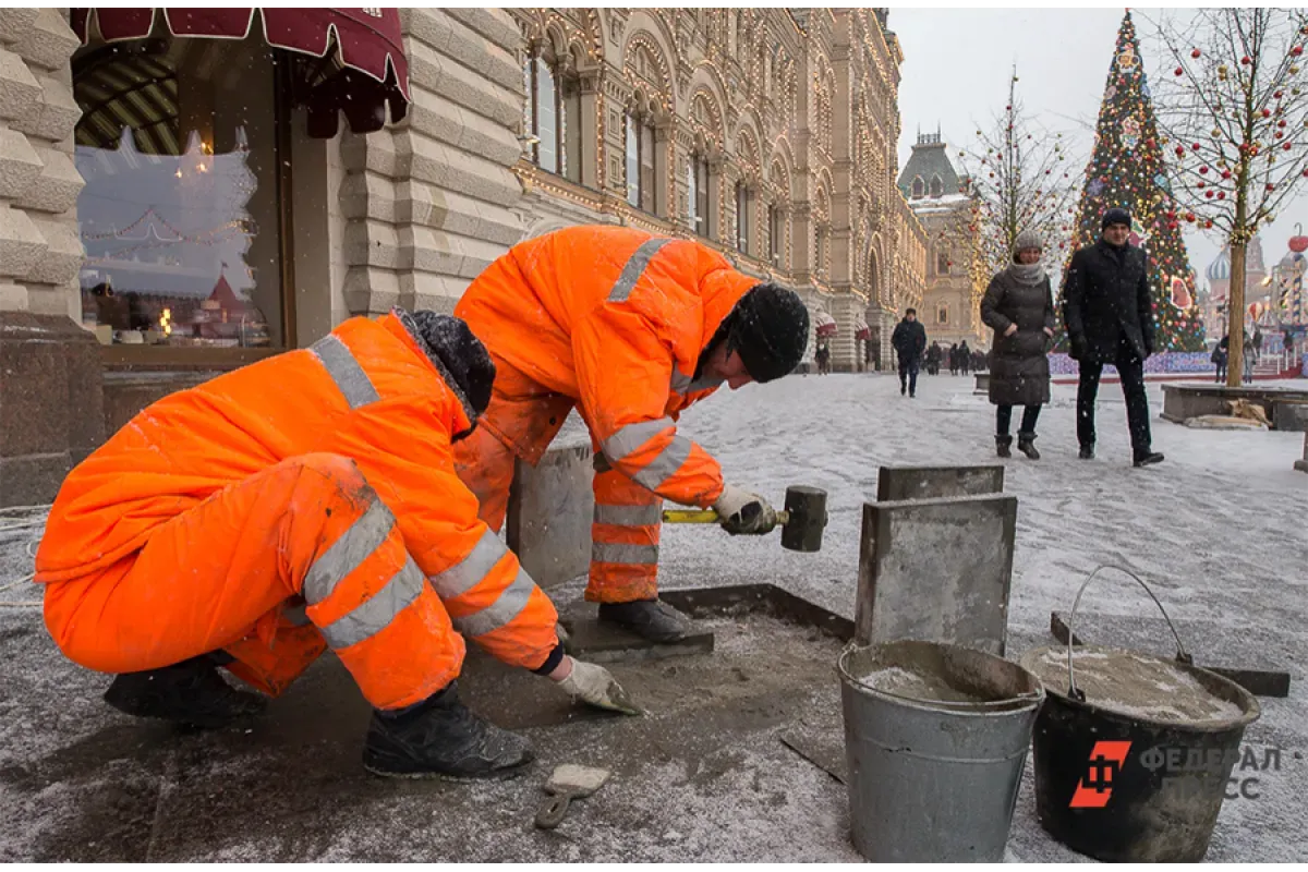 Рабочие ремонтируют тротуар 